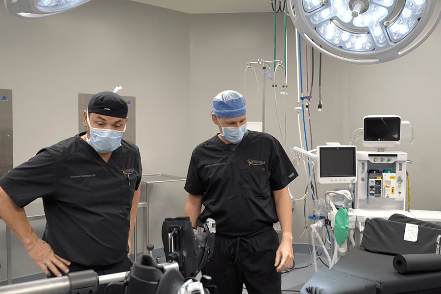 Dr. Yerasimides and his PA Jeremy Hamilton consult on a patient in a surgical suite