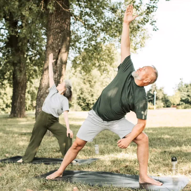 Man and woman doing yoga. outdoors